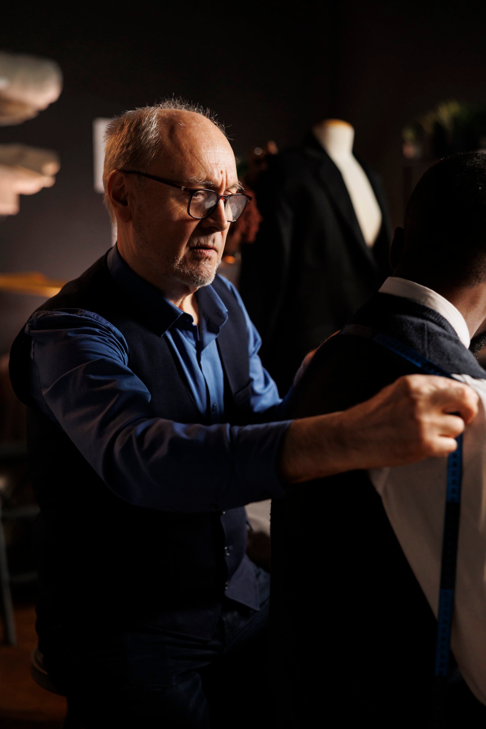 Apprentice suitmaker helping master